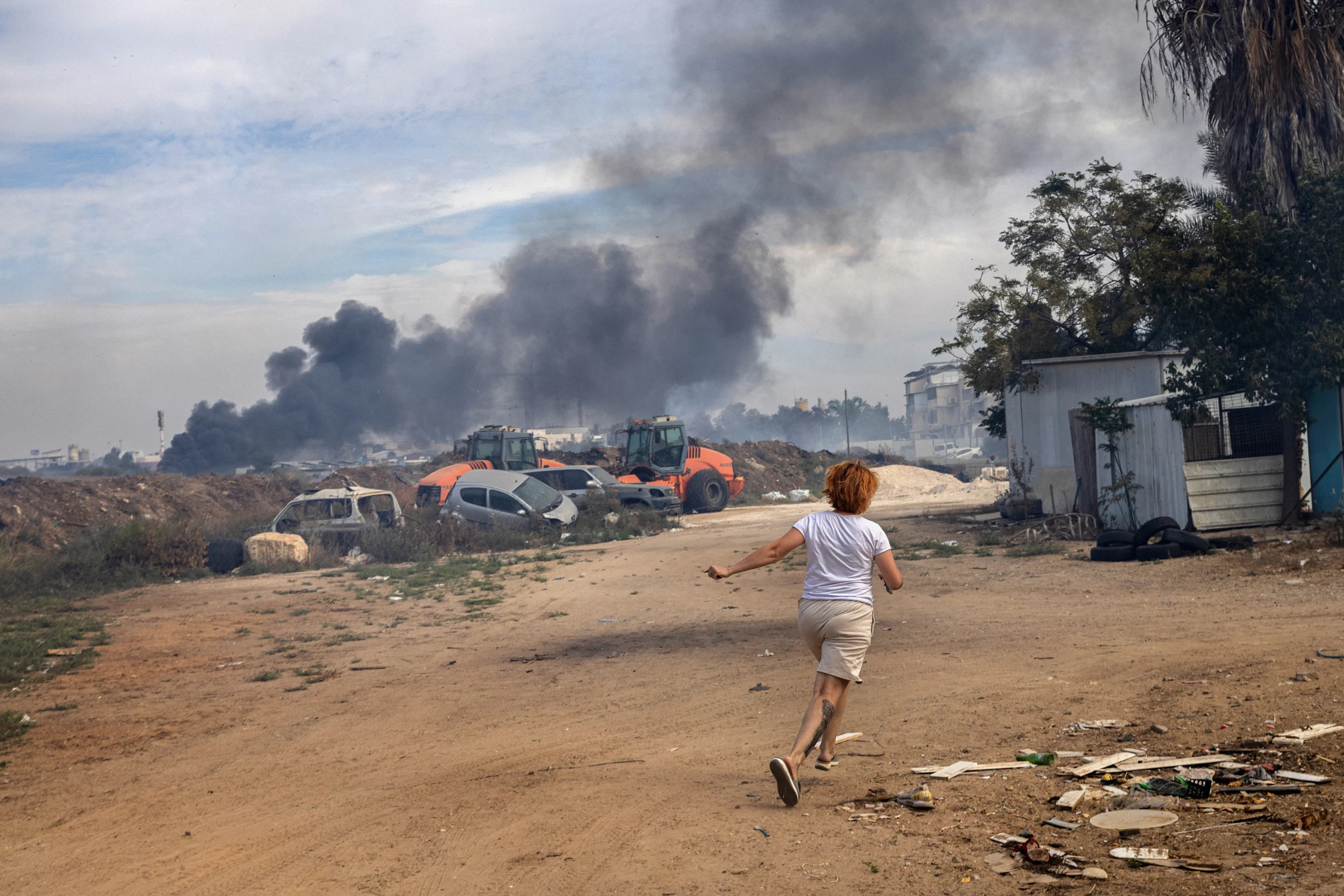 Evgenia Simanovich runs to the family home’s reinforced concrete shelter, moments after rocket sirens sounded in Ashkelon, Israel on Saturday, Oct. 7, 2023. (Tamir Kalifa/The New York Times)