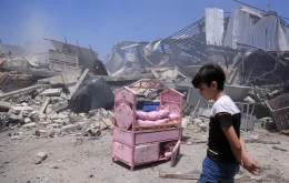 A Palestinian boy in front of the ruins of his house in Gaza City on Friday after it was destroyed in an Israeli airstrike.Credit...Samar Abu Elouf for The New York Times