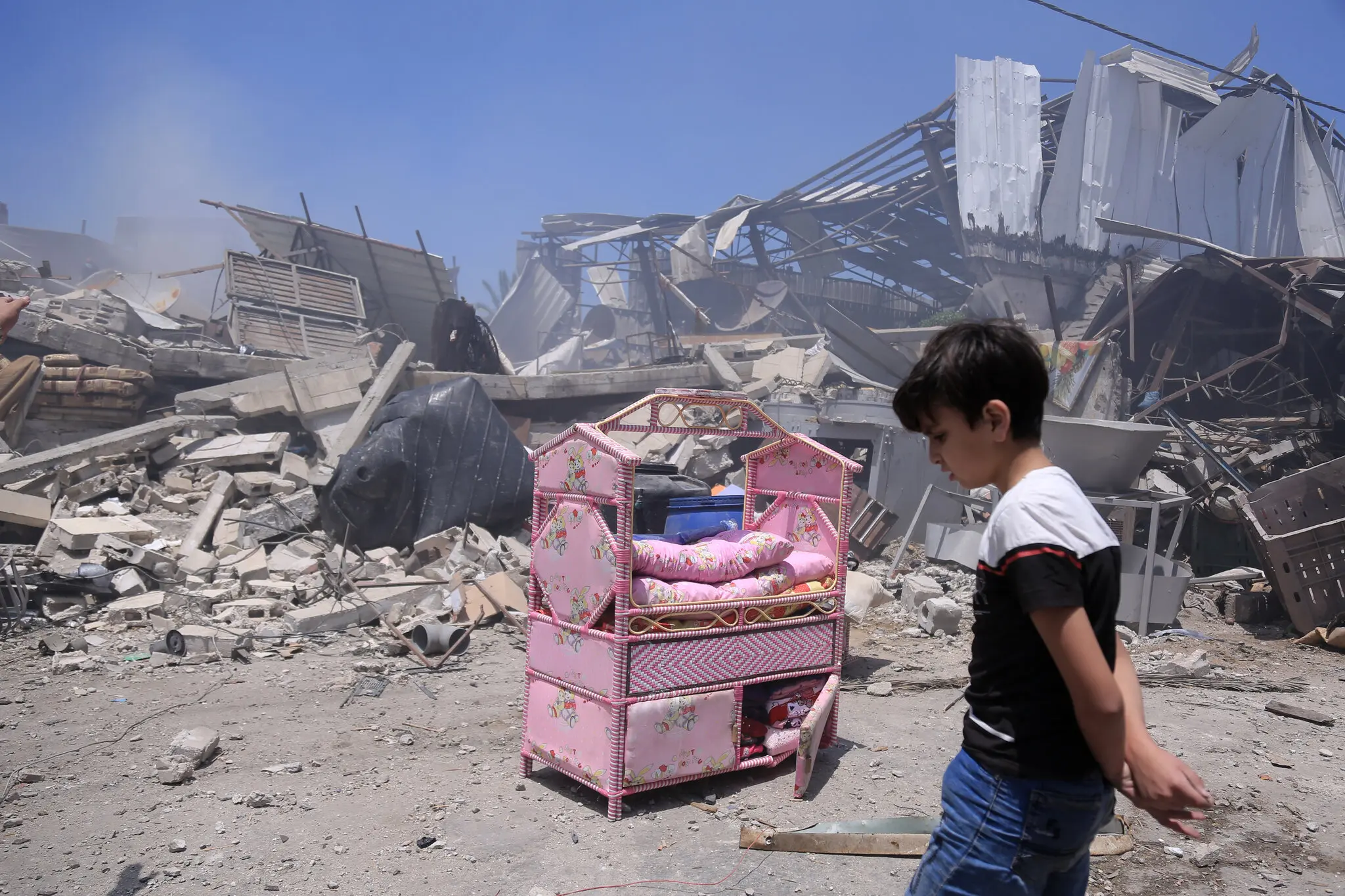 A Palestinian boy in front of the ruins of his house in Gaza City on Friday after it was destroyed in an Israeli airstrike.Credit...Samar Abu Elouf for The New York Times